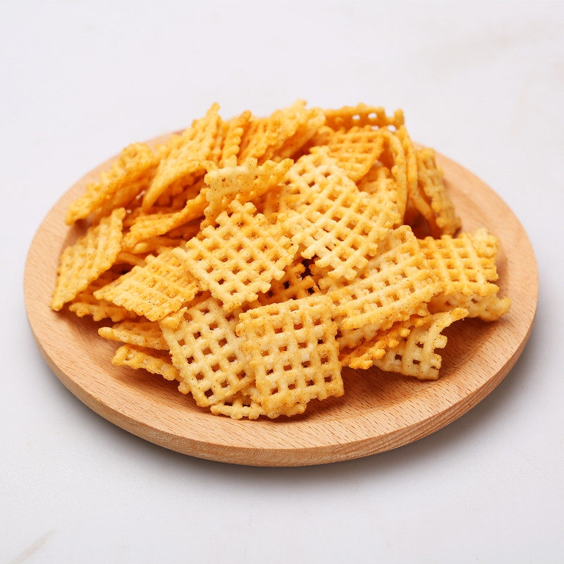 木质的灰色盘子里放着黄色网格纹路的锅巴